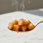 Spoon lifting a spoonful of Homemade Apple Pie Filling.
