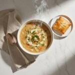 Warm Chicken Pot Pie Soup with flaky crust ready for dipping.
