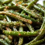 A serving of Parmesan Roasted Green Beans garnished with parmesan cheese